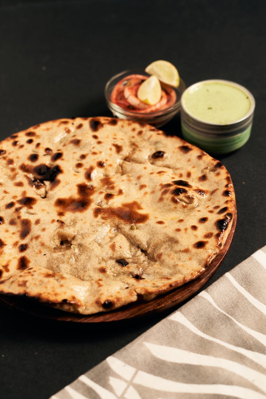 flatbread on wooden plate | Roti: Traditional chapati, roti and Phulka with clarified butter Photo by dhiraj jain on Pexels.com