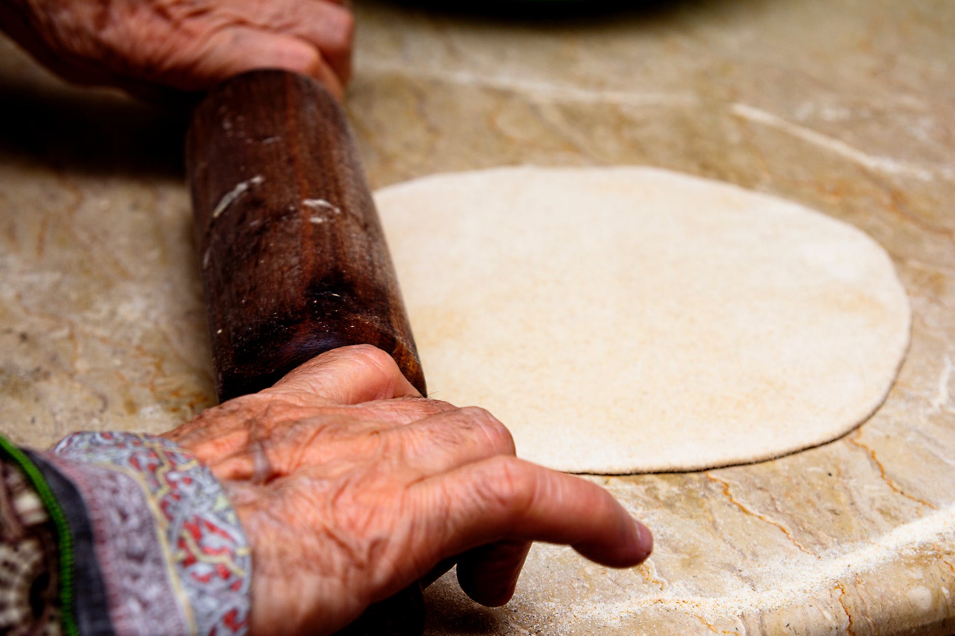 a person holding brown wooden rolling pin | Roti: Indian traditional chapati and Phulka is my favorite food